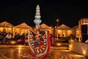 a woman dressed in a costume with a pyramid on her head at Sky Desert Safari Jaisalmer & Spa in Jaisalmer