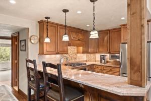 a kitchen with wooden cabinets and a island with chairs at Seasons Four #178 in Snowmass Village
