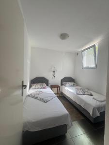 two beds in a room with white walls at Canj Cozy apartment 2 in Čanj