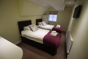 a small room with two beds and a tv at The Old Bear Inn in Cricklade