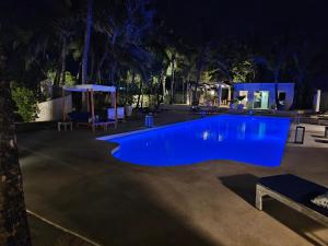 a large blue swimming pool at night at The Villa Luxury Suites Hotel in Diani Beach