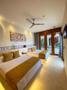 a bedroom with two beds and a ceiling fan at MAJO Hotel Boutique in Holbox Island