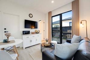 a living room with a couch and a table at Cosy Pukekohe Self-Contained Unit with Kitchenette in Pukekohe East