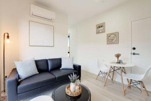 a living room with a blue couch and a table at Cosy Pukekohe Self-Contained Unit with Kitchenette in Pukekohe East