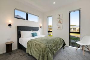 a bedroom with a bed and a large window at Cosy Pukekohe Self-Contained Unit with Kitchenette in Pukekohe East