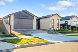 a house with a garage and a driveway at Cosy Pukekohe Self-Contained Unit with Kitchenette in Pukekohe East