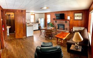 a living room with a couch and a table and a kitchen at Benzonia Rustic Resort in Benzonia