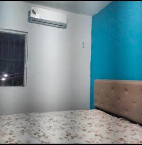 a bedroom with a bed and a blue wall at Casa naranjito in Cosoleacaque +10 photos