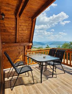 a patio with a table and chairs on a deck at Vikendice Una i Andrea in Bileća