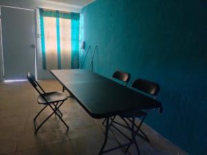 a table and chairs in a room with a blue wall at Casa naranjito in Cosoleacaque
