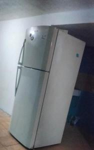 a white refrigerator freezer sitting in a room at Casa naranjito in Cosoleacaque