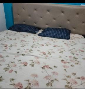 a bed with a floral bedspread and pillows on it at Casa naranjito in Cosoleacaque