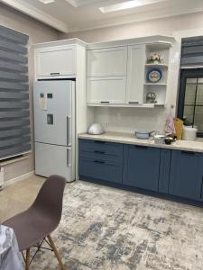 a kitchen with blue cabinets and a white refrigerator at Luxury Tashkent house Zenith in Tashkent