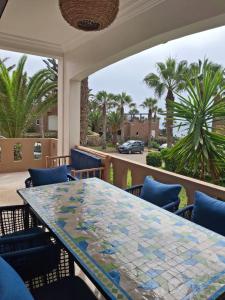 a mosaic table on a balcony with palm trees at Villa sur la plage in Tiznit