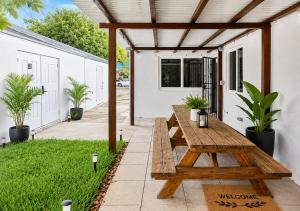 a wooden picnic table on a patio with plants at 05 Modern Co-Living Home with Newly Renovated Private Rooms Available in Miami