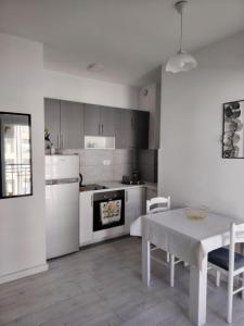 a kitchen with white appliances and a table with chairs at Tanja Apartment in Podgorica