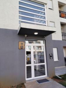 a door to a building with a sign on it at Tanja Apartment in Podgorica
