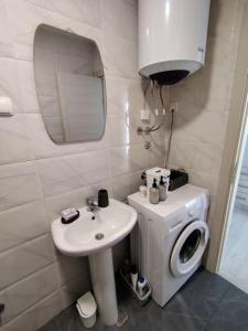 a bathroom with a sink and a washing machine at Tanja Apartment in Podgorica +5 photos