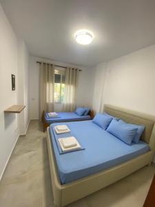 a bedroom with two beds with blue pillows at Beachfront Apartment Durres in Durrës