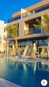a building with a swimming pool in front of a building at V Beach in Jeddah