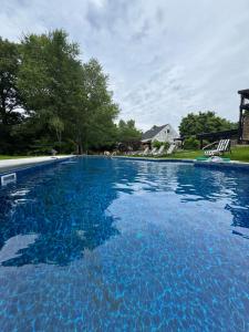 a large swimming pool with blue water in a yard at The Connecticut River Valley Inn Hartford South/Glastonbury in Glastonbury