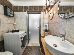a bathroom with a sink and a washing machine at Casa Katrine in Lakíthra +38 photos