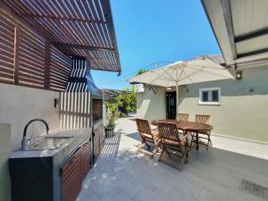 a patio with a table and chairs and an umbrella at Casa Katrine in Lakíthra