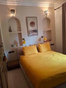 a bedroom with a large bed with yellow sheets at Villa sur la plage in Tiznit
