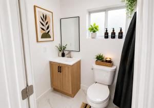 a bathroom with a toilet and a sink and a mirror at 05 Modern Co-Living Home with Newly Renovated Private Rooms Available in Miami +13 photos
