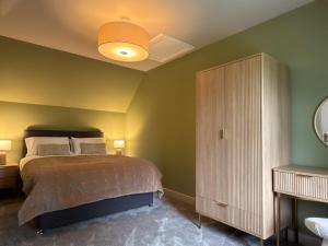 a bedroom with a large bed and a cabinet at Greenkeepers Cottage in Tobermory