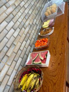 a table with fruits and vegetables in baskets on it at Pousada Posto Junior - Madalena CE in Madalena