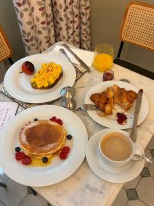a table with plates of breakfast food and a cup of coffee at The Norfolk, Paddington in London