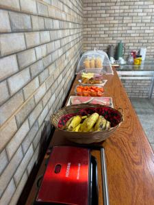 a table with a basket of bananas and other fruits and vegetables at Pousada Posto Junior - Madalena CE in Madalena