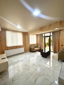 a large living room with a couch and a table at Guest House Ucha in Stantsiya Chakva