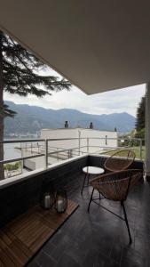 a patio with two chairs and a table on a roof at Riflesso Apartment in Blevio