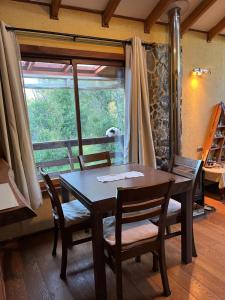 a dining room with a table and chairs and a window at Refugio Lawentu Linares Colbun in Los Rabones +13 photos