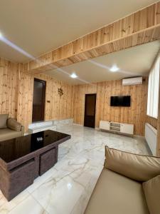 a living room with a couch and a flat screen tv at Guest House Ucha in Stantsiya Chakva