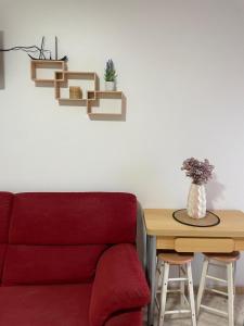 a living room with a red couch and a table at Atico Marin playa in Marín