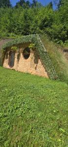 a brick building with ivy growing on it in a field at lazy trout house in Criva