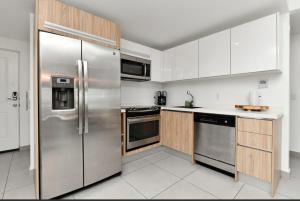 a kitchen with stainless steel refrigerator and wooden cabinets at Harbour House apt 410 in Oranjestad
