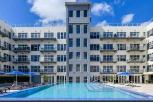 a large building with a swimming pool and blue umbrellas at Harbour House apt 410 in Oranjestad