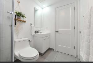 a white bathroom with a toilet and a sink at Harbour House apt 410 in Oranjestad +20 photos