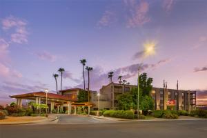 a parking lot with a hotel and palm trees at Best Western Plus Scottsdale Thunderbird Suites in Scottsdale