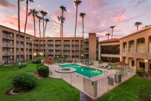 a resort with a swimming pool and palm trees at Best Western Plus Scottsdale Thunderbird Suites in Scottsdale