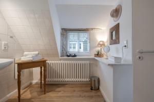 a bathroom with a sink and a window at Beachday Kampen in Kampen