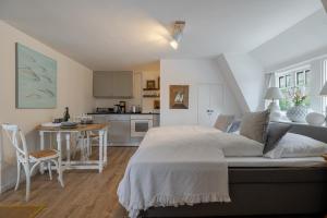 a bedroom with a large bed and a kitchen at Beachday Kampen in Kampen