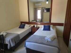 a hotel room with two beds and a mirror at Palace Hotel Jacutinga JS in Jacutinga +20 photos