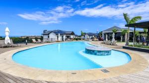 a swimming pool at a resort with tables and chairs at Ballito Hill's Serenity Suite in Ballito