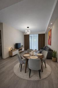 a living room with a table and chairs and a couch at Relax Apartments in Crystal Residence Bakuriani in Bakuriani