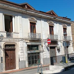 a white building with brown doors and windows on a street at Domus Liberty Luxury House in Sala Consilina